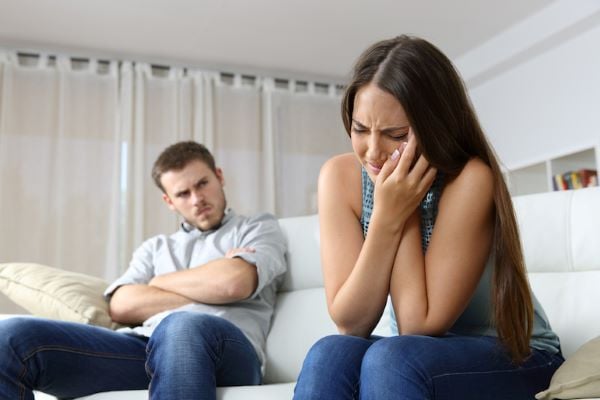 woman holding cheek in pain