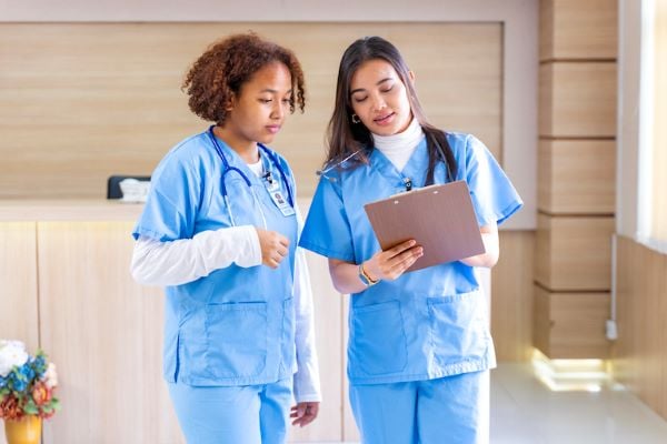 two female nurses looking at chart